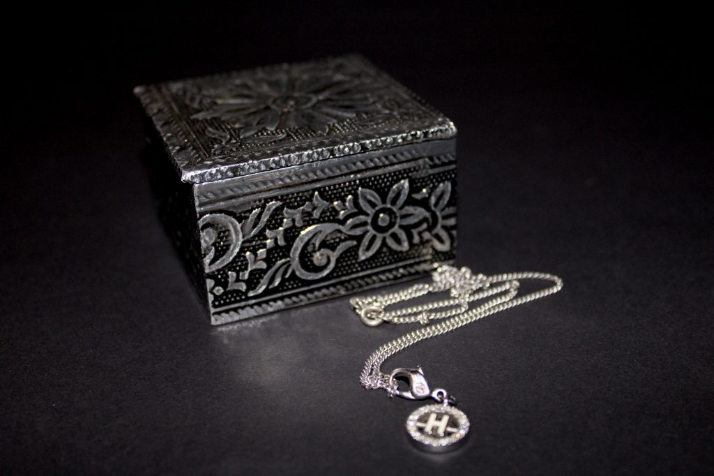 Silver jewelry box with a silver necklace, letter H pendant surrounded by swarovski diamonds